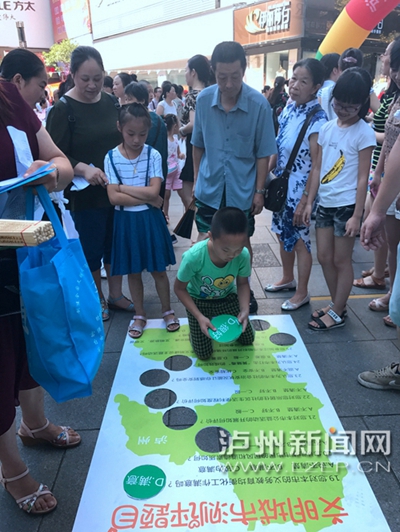 市民在宣傳點(diǎn)參加創(chuàng)文趣味游戲。 記者 朱虹 攝